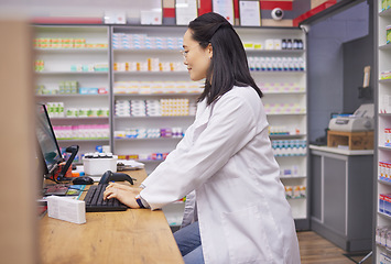 Image showing Pharmacy, woman from Japan and checkout counter for prescription drugs and customer service. Healthcare, pills and asian pharmacist in retail store typing on computer to check stock inventory online.