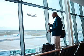 Image showing Black man with phone, airport window and plane taking off, checking flight schedule terminal for business trip. Technology, travel and businessman reading international travel restrictions app online