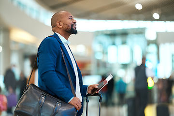 Image showing Passport, flight and businessman standing in the airport checking the departure times or schedule. Travel, work trip and professional African male waiting by terminal with his ticket to board plane.