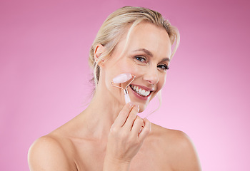 Image showing Beauty, face roller and portrait of woman doing facial massage for dermatology and cosmetics. Happy aesthetic person on pink background for skincare, self care and rose quartz results for health glow