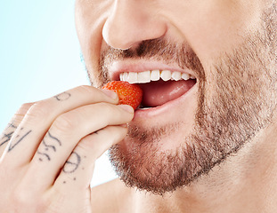 Image showing Health, eating and strawberry with mouth of man for diet, detox and nutrition product. Wellness, smile and teeth with model and biting fruit closeup for vitamin c, glow and fiber in blue background