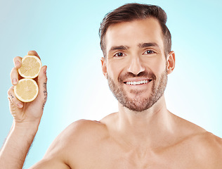 Image showing Man, skincare and studio portrait with lemon for health, nutrition and cosmetic wellness by blue background. Happy young model, fruit and vitamin c for natural detox, facial skin glow and beauty