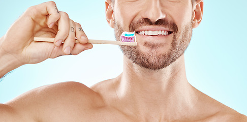 Image showing Smile, mouth or man brushing teeth with dental toothpaste for healthy oral hygiene grooming in studio. Eco friendly, self care or male model cleaning with a product or natural bamboo wood toothbrush