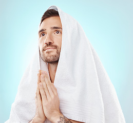 Image showing Prayer, thinking and worship with man and towel for hope, spiritual and Catholic faith. Respect, religion and Holy spirit with guy and hands for believer, humble and Christianity with blue background