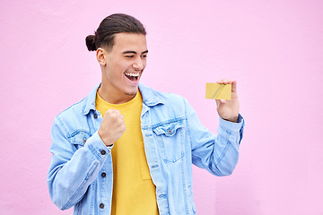 Image showing Happy, celebrate and man with a credit card in studio with success, excitement and celebration. Happiness, excited and male winner doing ecommerce shopping with gold bank account by a pink background