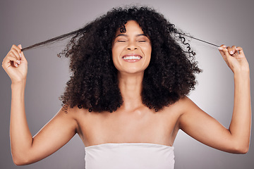Image showing Hair in hands, beauty and face of black woman for wellness, natural growth and curly style. Salon, luxury cosmetics and happy girl smile holding strand for keratin treatment result on gray background