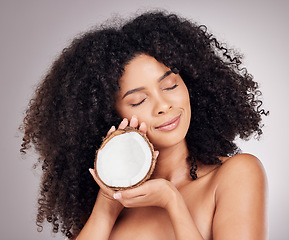 Image showing Coconut, beauty and black woman isolated on studio background for natural skincare, face and hair dream. Afro model or young person sleeping with fruit product or healthy oil benefits for dermatology