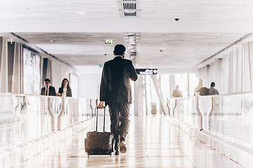 Image showing Businessman at airport corridor walking to departure gates.