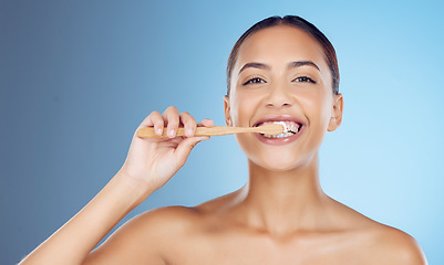 Image showing Bamboo toothbrush, toothpaste and portrait of woman for dental wellness, healthy cleaning or model cosmetics. Happy female teeth, eco wooden brush and mouth for smile, face and studio blue background