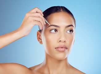 Image showing Eyebrow, tweezers and woman in studio for beauty, grooming and hygiene on blue background space. Hair removal, epilation and brow tool by girl skin model relax with luxury, product and cosmetic care