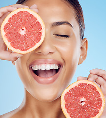Image showing Grapefruit, laughing and woman with face for beauty on studio background, wellness benefits and smile. Happy model, diet and citrus fruits for natural detox, healthy skincare and vitamin c aesthetic