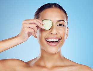 Image showing Cucumber, woman and portrait of smile for skincare, face beauty and wellness diet on studio background. Happy model, eyes and green fruits cosmetics for detox, facial nutrition and aesthetic benefits