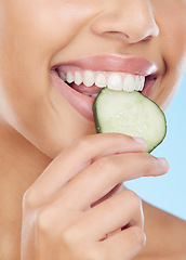 Image showing Closeup, mouth and cucumber by woman in studio for wellness, detox or skincare on blue background. Fruit, snack and girl model with snack during beauty, facial and happy with organic product isolated