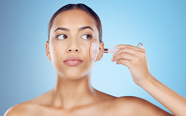 Image showing Woman, beauty and face massage with roller, facial product and aesthetic skincare in studio. Young model, crystal stone treatment and wellness for natural cosmetics, rose quartz dermatology and salon