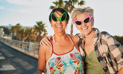 Image showing Funny, sunglasses and senior women hug, happy and laugh on fun vacation, trip or crazy summer holiday with mockup. Face, friends and elderly lady embrace while travel, bond or enjoy retirement