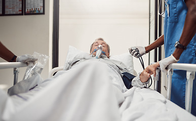 Image showing Hospital, senior patient and doctors for emergency on a bed with oxygen mask for healthcare. Sick old man with health problem and medical team er or surgery in theater for life insurance and help