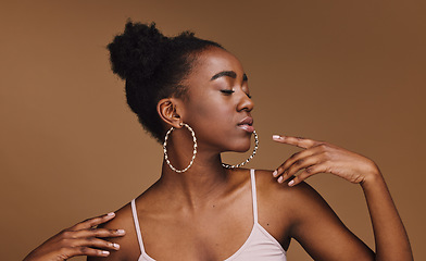 Image showing Black woman, pose or fashion hairstyle on isolated brown background in relax self love, trendy or cool style promotion. Confident, hands or beauty model with makeup cosmetics, natural hair or jewelry