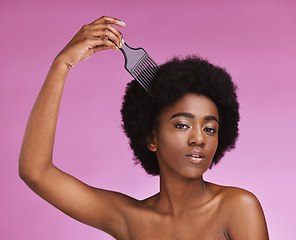 Image showing Portrait, hairstyle or afro brush on beauty studio background in relax grooming routine, texture maintenance or growth wellness. Black woman, comb or natural hair and skincare makeup on isolated pink