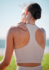 Image showing Massage, shoulder pain and fitness with woman at beach for yoga, workout and exercise training. Burnout, injury and physical therapy with girl in city park for training, sport and pilates goals