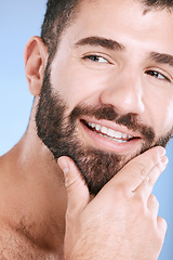 Image showing Face, beauty and skincare with a man model in studio on a blue background for natural wellness or grooming. Idea, beard and skin with a handsome young male thinking about cosmetics or treatment