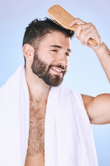 Image showing Hair, brush and man in studio for beauty, grooming and hygiene against a blue gradient background. Haircare, hairstyle and guy model brushing, styling and happy with product, results and treatment
