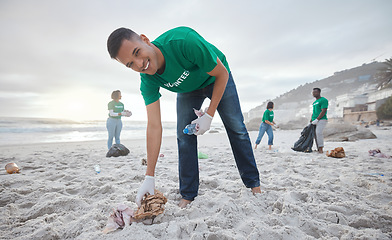 Image showing Volunteer portrait, beach cleaning or man for recycling plastic bottle for community service, pollution and earth day. Smile, ngo team or sand trash for climate change, nature and helping environment