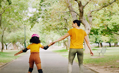Image showing Mother, child and skating with roller skates at nature park for exercise, balance and freedom. Woman and black girl kid or family outdoor to play with helmet for safety, trust and love in summer