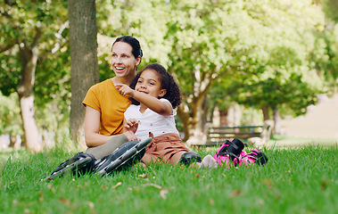 Image showing Family, mother and child in park with rollerblading outdoor, relax on grass and fun in nature with happy people. Woman, girl and taking a break, sports and quality time together with love and care