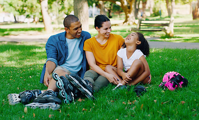 Image showing African family, girl and park with rollerblades, interracial bonding and laugh for comic joke, happy or holiday. Black man, woman and child with happiness, care and diversity on grass for vacation