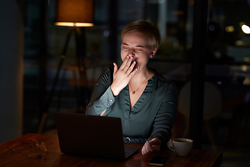 Image showing Tired, late and woman working on a laptop, yawning and feeling burnout in a dark office. Sleepy, overworked and employee with fatigue doing overtime for a project deadline at night on a computer