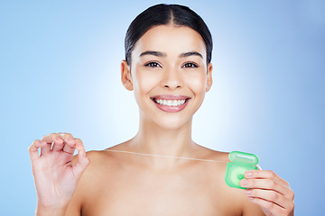 Image showing Face, floss teeth and dental with woman, hygiene and beauty with grooming and container on blue background. Hands, string and oral care product, healthy gums with fresh breath, health and portrait