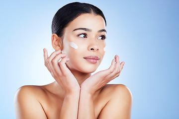 Image showing Woman, face and skincare moisturizer, cosmetics or beauty against a blue studio background. Female applying cosmetic product, lotion or cream for facial treatment or self love or care on mockup