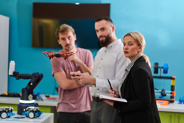 Image showing A group of students working together in a laboratory, dedicated to exploring the aerodynamic capabilities of a drone