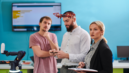 Image showing A group of students working together in a laboratory, dedicated to exploring the aerodynamic capabilities of a drone