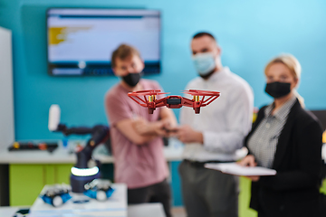 Image showing A group of students working together in a laboratory, dedicated to exploring the aerodynamic capabilities of a drone