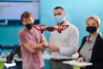 Image showing A group of students working together in a laboratory, dedicated to exploring the aerodynamic capabilities of a drone