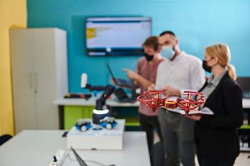 Image showing A group of students working together in a laboratory, dedicated to exploring the aerodynamic capabilities of a drone