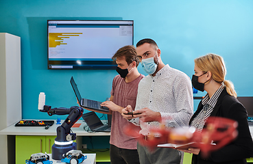 Image showing A group of students working together in a laboratory, dedicated to exploring the aerodynamic capabilities of a drone