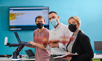 Image showing A group of students working together in a laboratory, dedicated to exploring the aerodynamic capabilities of a drone