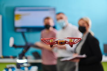 Image showing A group of students working together in a laboratory, dedicated to exploring the aerodynamic capabilities of a drone