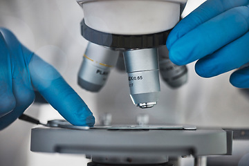 Image showing Science, microscope and hands for research and analysis by doctor or scientist in laboratory. Zoom on medical dna, particle or bacteria to study for biotechnology, medicine and innovation development