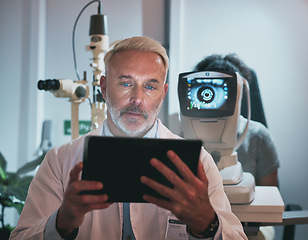 Image showing Digital tablet, optometry and man in a clinic doing optic research during eye care consultation. Ophthalmology, healthcare and senior male optometrist working on mobile device while doing vision test