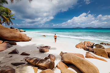 Image showing Man enjoying Anse Patates picture perfect beach on La Digue Island, Seychelles.