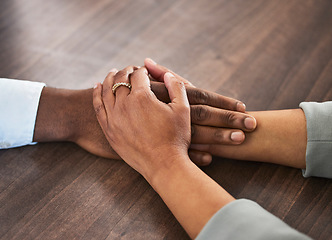 Image showing Support, help and couple holding hands for trust, empathy and unity in crisis, cancer or bad news. Solidarity, care and man and woman together on table for praying, comfort and prayer, hope or love.