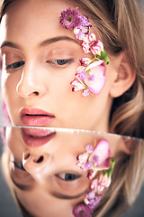 Image showing Beauty face, mirror reflection and model with flower product, sustainable agriculture and natural skincare. Facial makeup, nature plant cosmetics and eco friendly woman isolated on studio background
