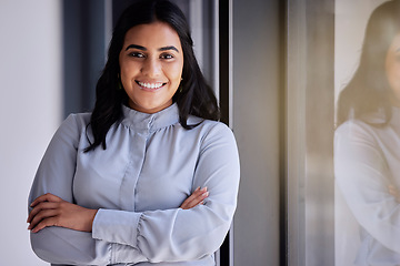 Image showing Portrait, window and vision with a business woman in the office, standing arms crossed for growth. Mission, motivation and smile with a happy female employee at work for corporate company success