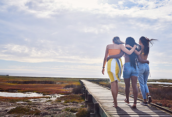 Image showing Relax, group and boardwalk with friends at beach for travel vacation, support or summer break with blue sky mockup. Diversity, holiday and nature with women walking together for bonding, hug or peace