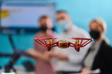 Image showing A group of students working together in a laboratory, dedicated to exploring the aerodynamic capabilities of a drone