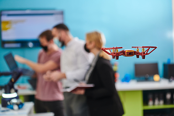 Image showing A group of students working together in a laboratory, dedicated to exploring the aerodynamic capabilities of a drone