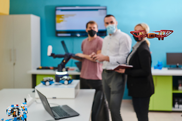 Image showing A group of students working together in a laboratory, dedicated to exploring the aerodynamic capabilities of a drone